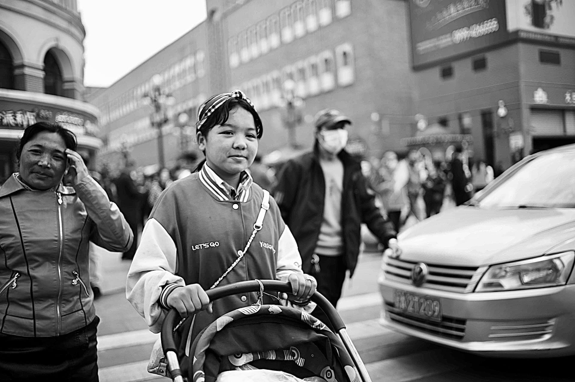 The child pushing the baby stroller